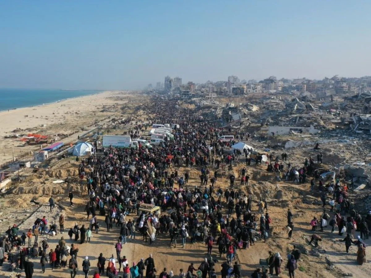 Dezenas de milhares de palestinos, deslocados pelas forças israelenses, retornam para suas casas pela rua Al-Rashid, na faixa costeira, após o acordo de cessar-fogo na cidade de Gaza - Metrópoles