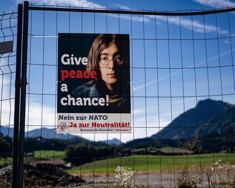 Poster of John Lennon with the words Give Peace A Chance on a fence in Switzerland.