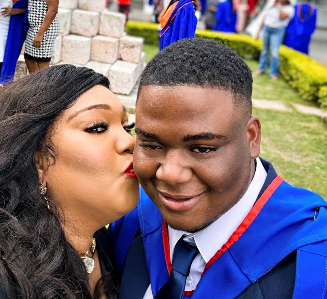 Trecha Thomas kisses her son, Jean-Pierre Samuels, at his graduation ceremony for his bachelor’s degree.