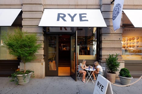 Two women sit at an outdoor table outside Rye bakery's storefront in SoHo