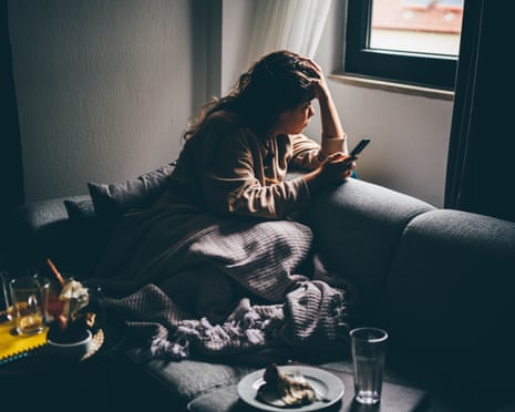 Sad and depressed woman using smartphone at home