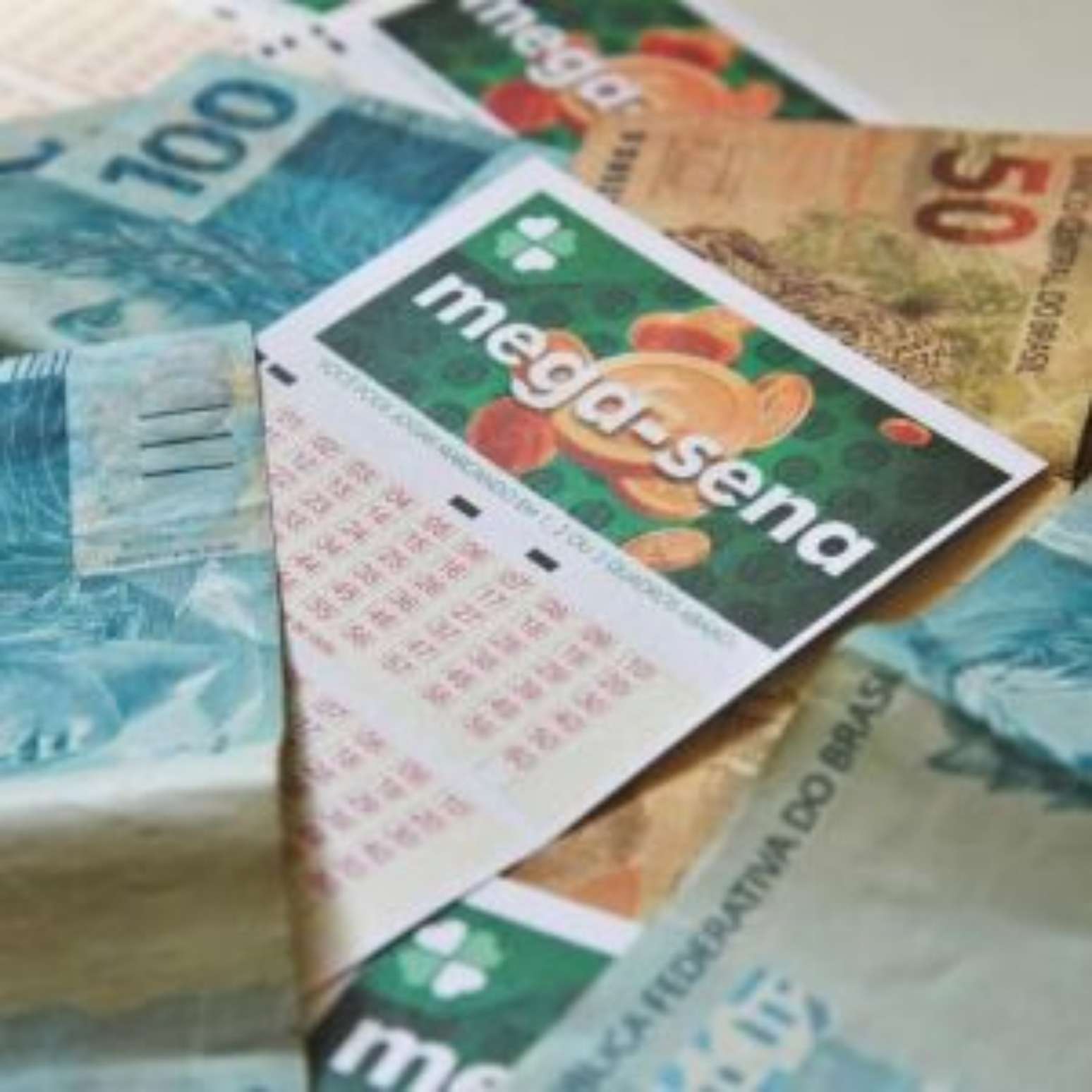 Cartelas da Mega-Sena e dinheiro.